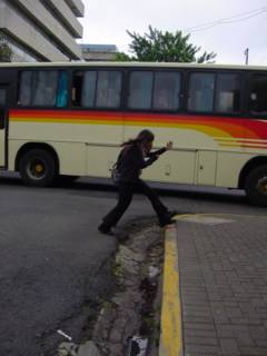 someone on a skateboard taking a picture at a graffiti painted bus