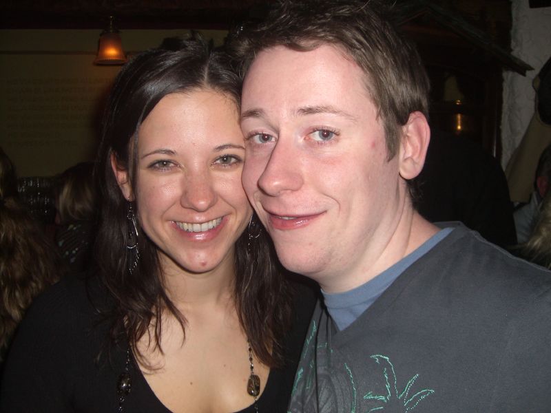 young couple taking picture while smiling for camera