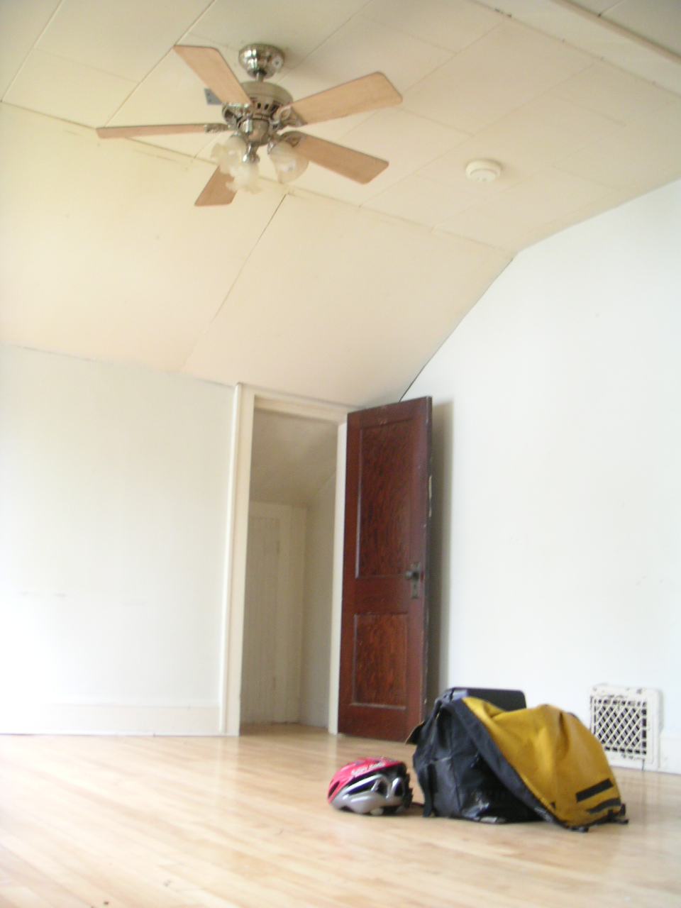 a suitcase is sitting on the floor near a ceiling fan