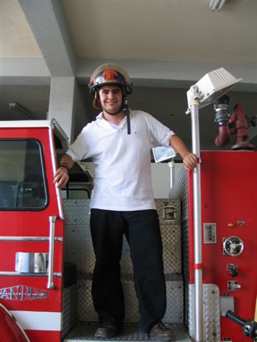 a man standing on the side of the stairs in front of a fire truck