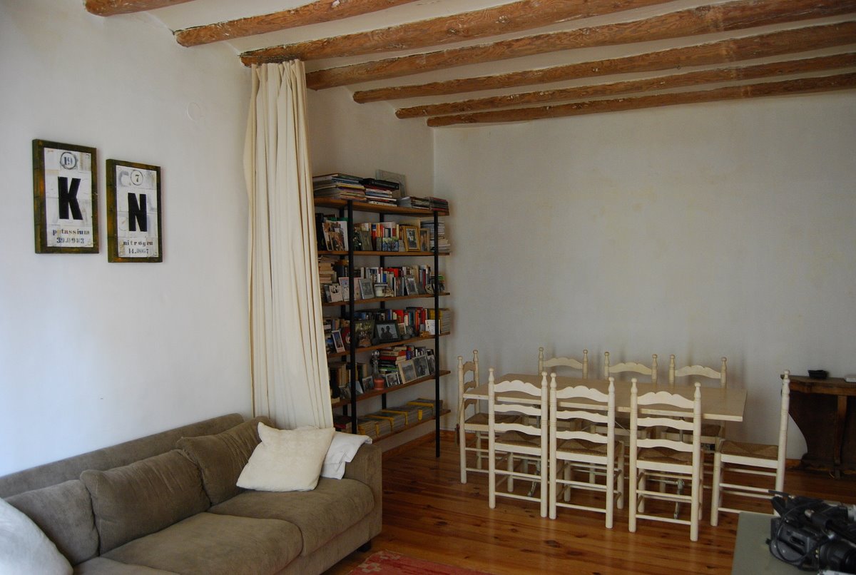 a living room with sofa, book shelf, and table