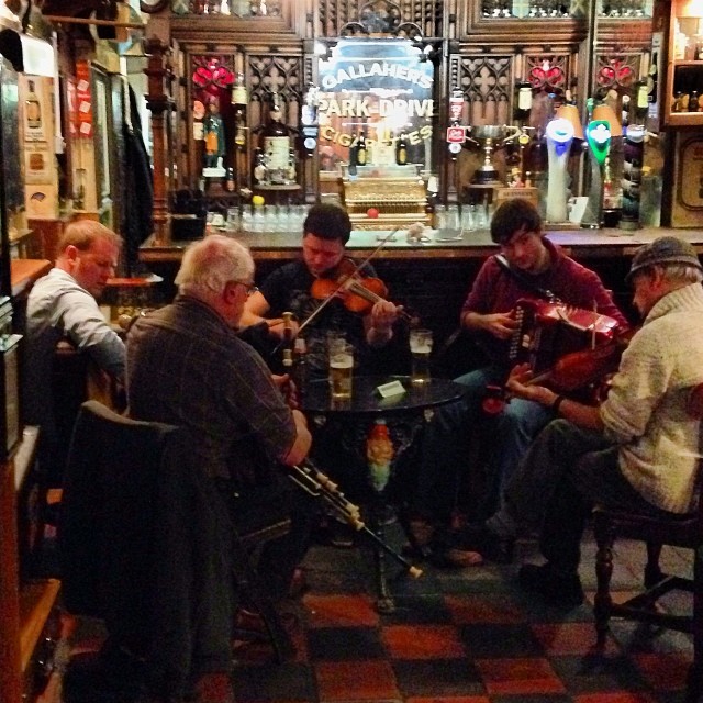 a group of men playing instruments in a pub