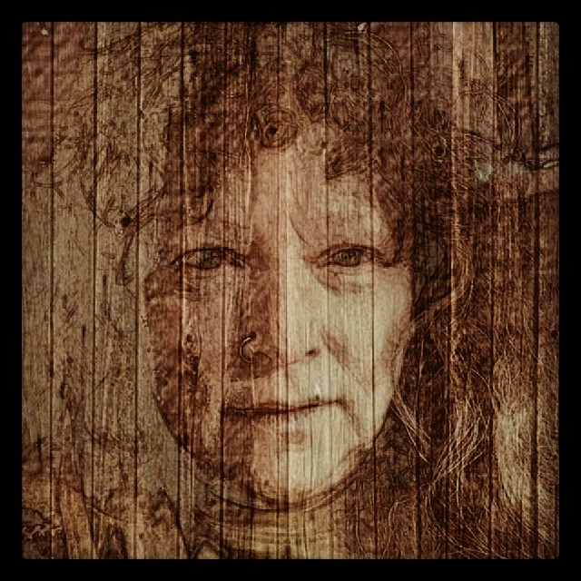 a drawing on wood of a woman's face
