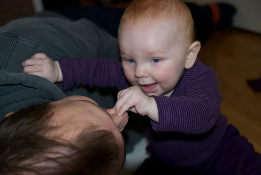 a close up of a person holding and playing with a child