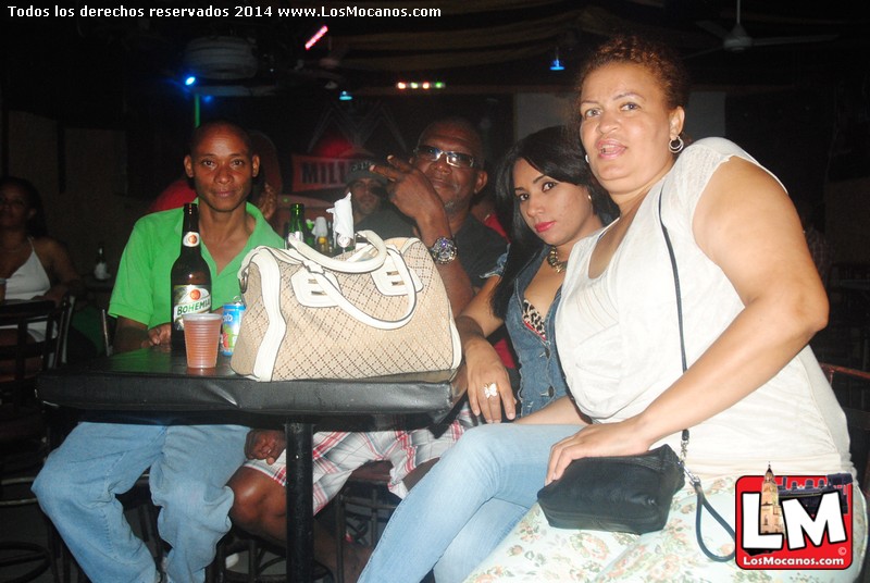 several people are gathered around a table with a purse on it