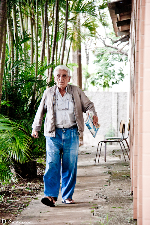 an elderly man is walking down the path outside