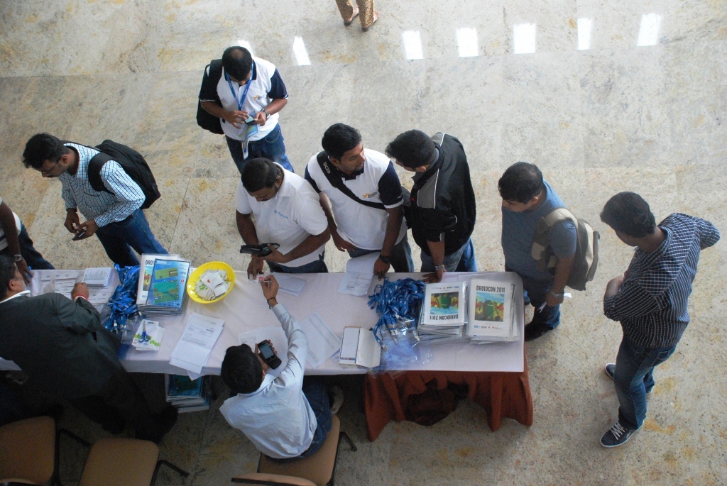 several people standing around a white table with cakes on it