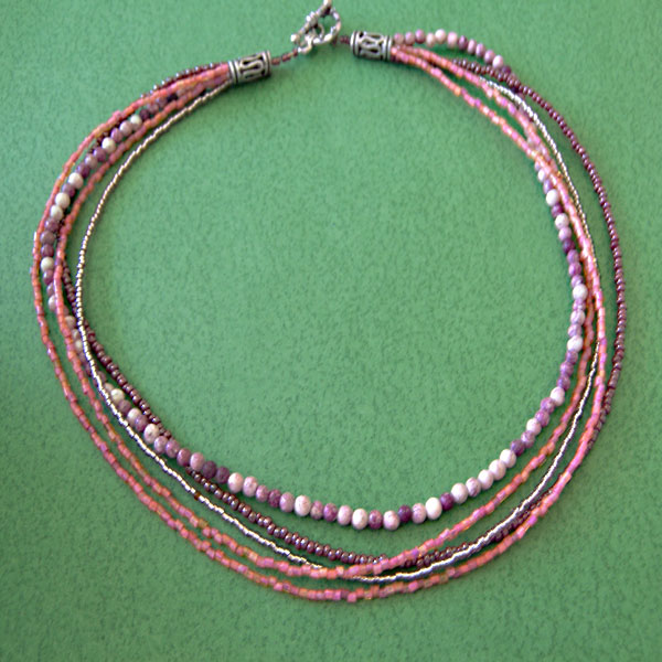 three strand beaded necklace on green cloth