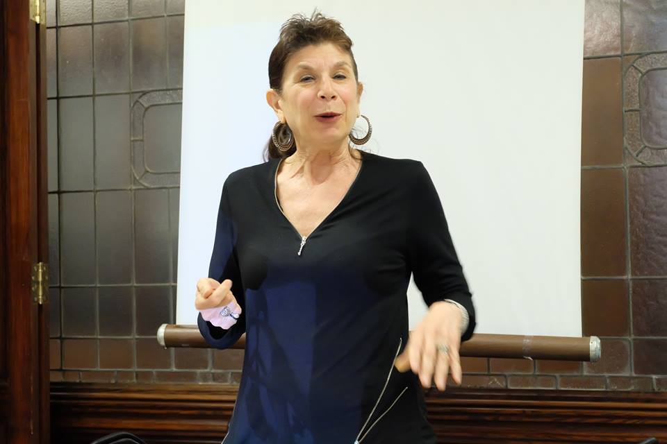 a woman is speaking while listening to a lecture