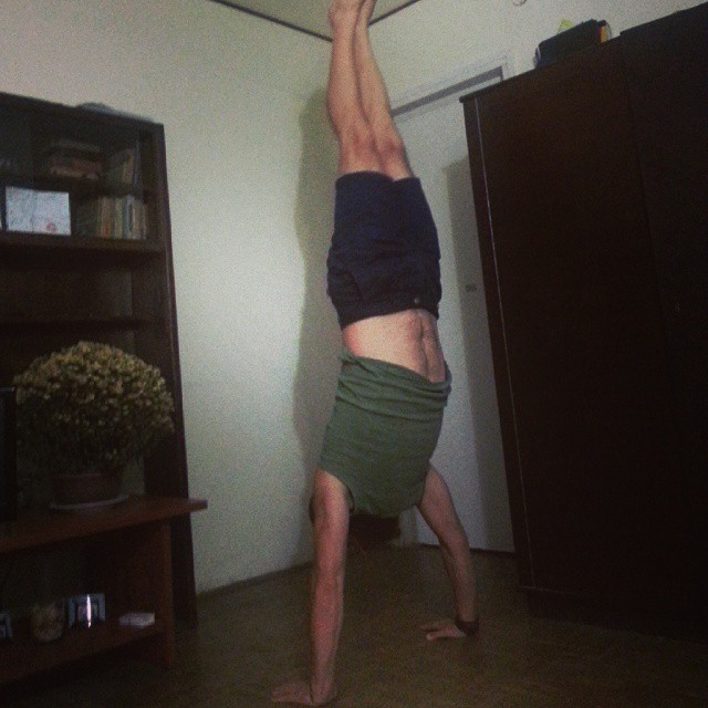 a man is doing a handstand in the living room