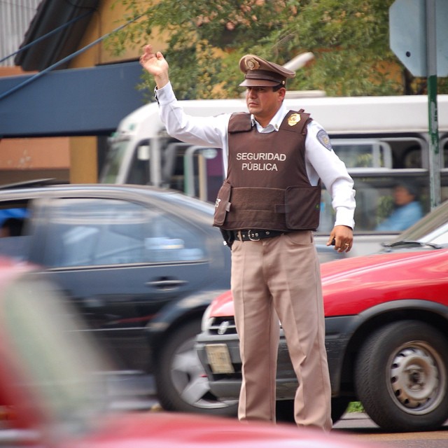 the policeman is directing traffic at an intersection