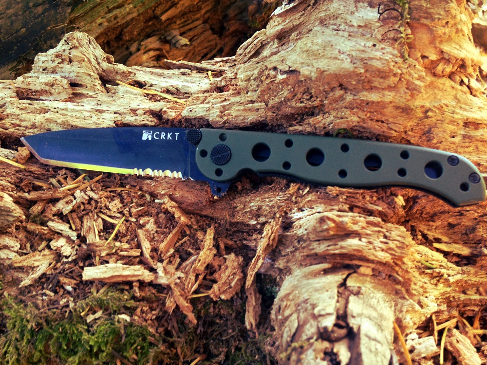 a knife on a rock next to a tree stump