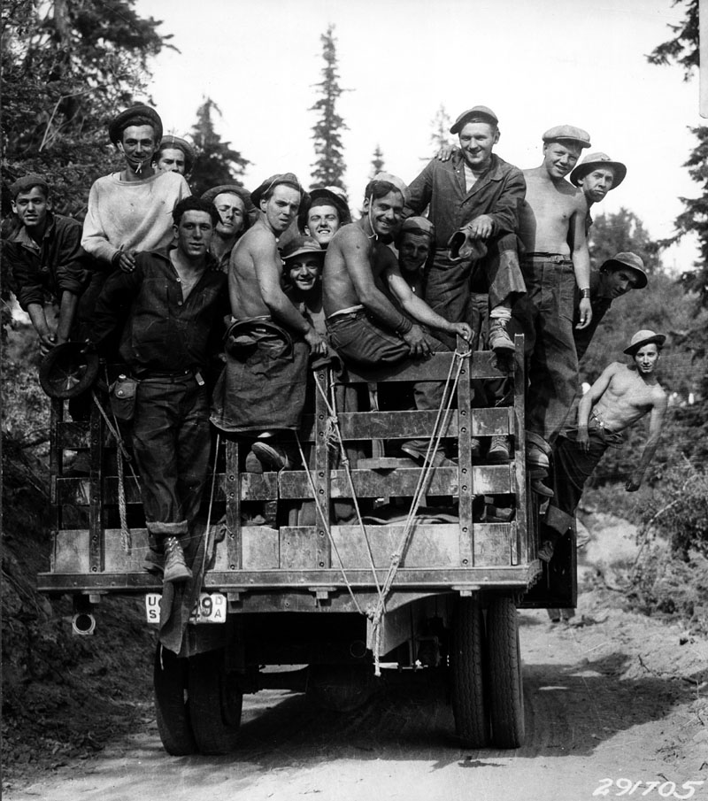 black and white pograph of people on a flat bed truck