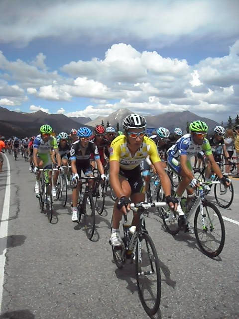 a group of bicyclists riding down the road