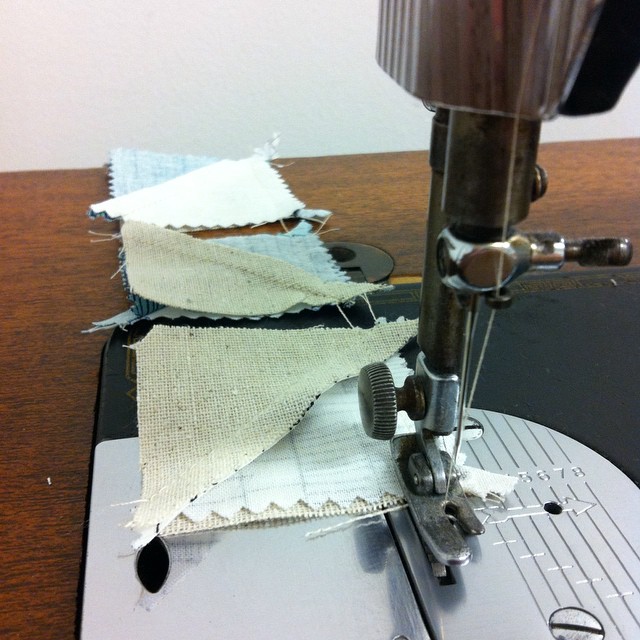 a sewing machine stitches fabric into several pieces of cloth