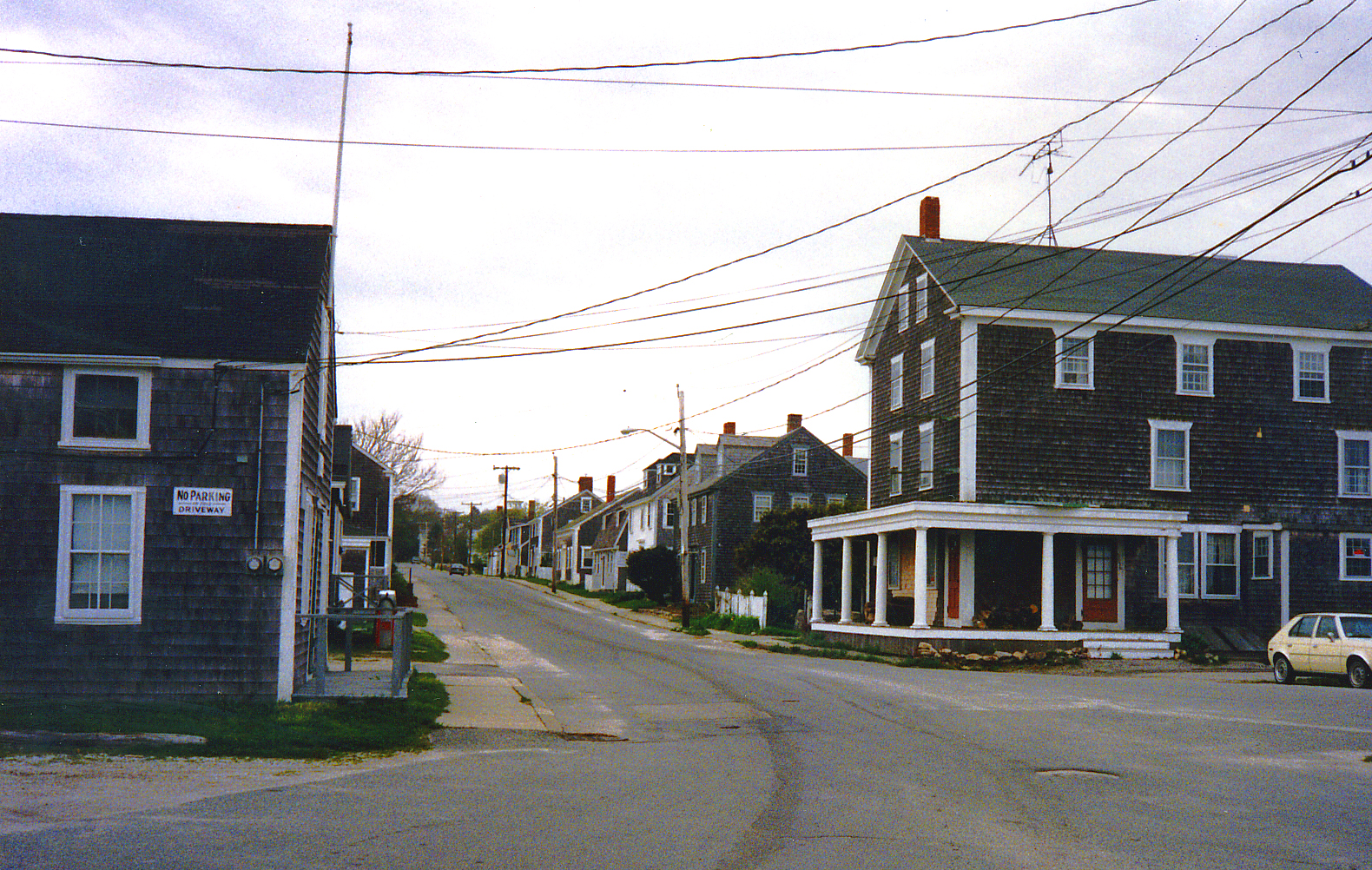 houses and an old car line the street