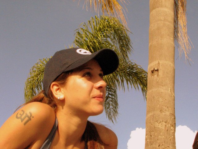 a woman wearing a hat holding a yellow frisbee