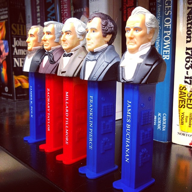 a row of bookshelves that have statues of presidents on them