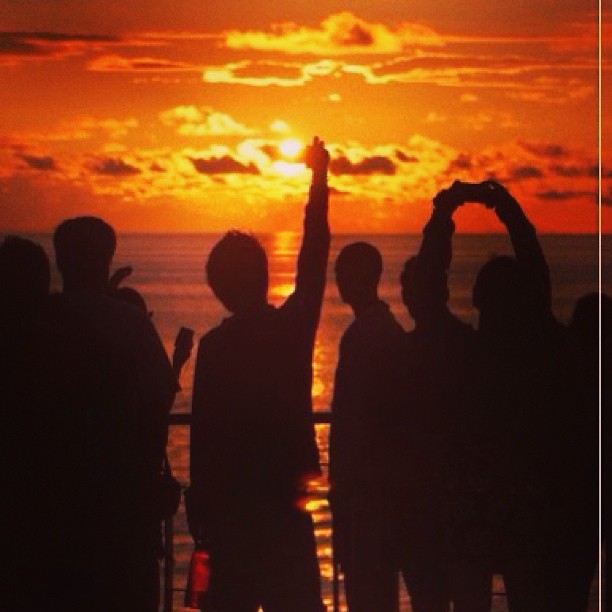 people on the ocean watching the sun set