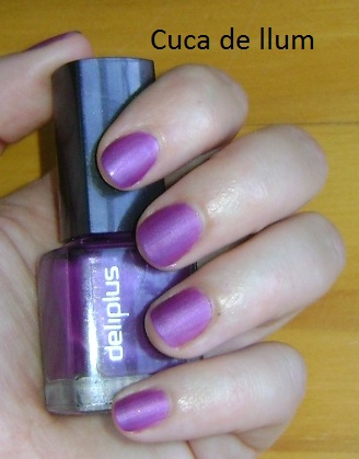 a woman is holding a bottle of purple nail polish