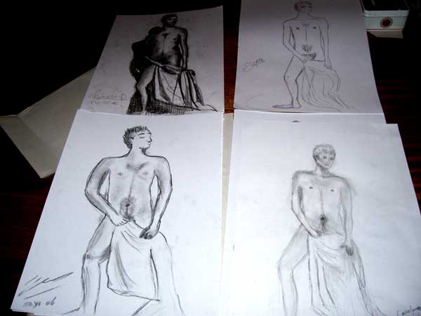 three drawings of male torsos are lined up on top of a table