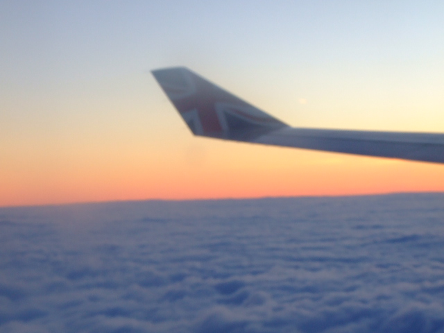 the view of an airplane wing above the clouds from the window