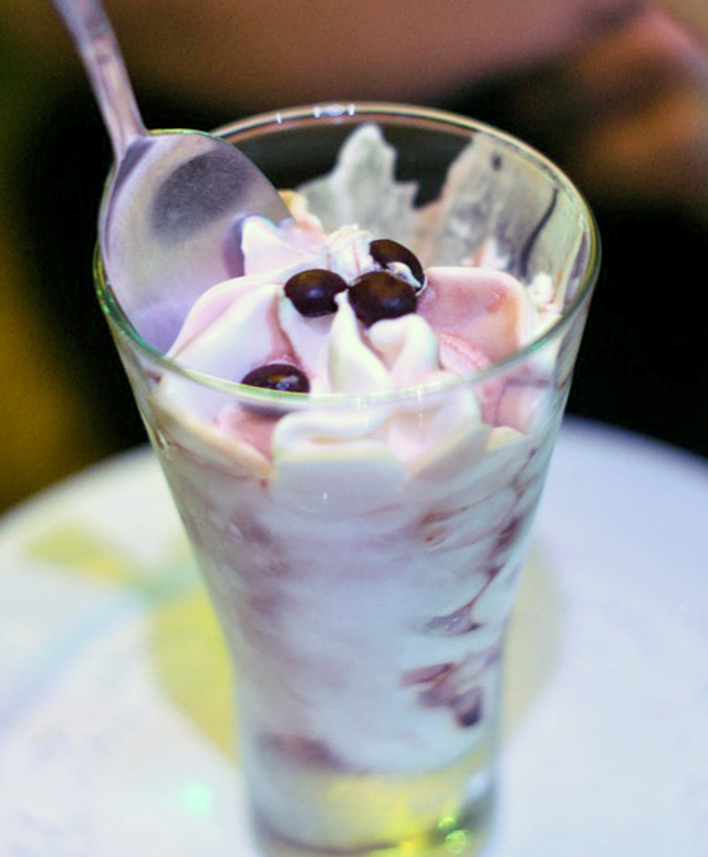 a dessert with ice cream and cranberries in a glass