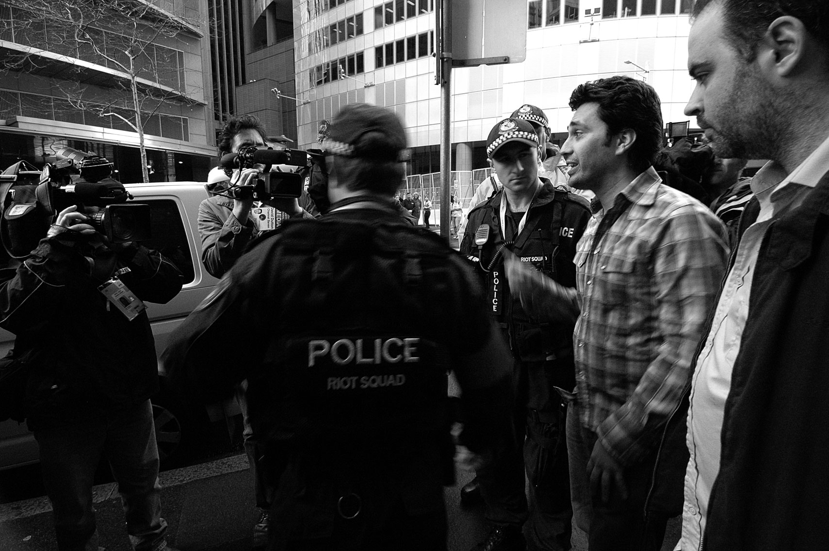 two police officers with cameramen filming them