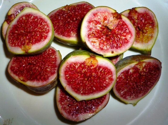 a white plate full of cut up figs
