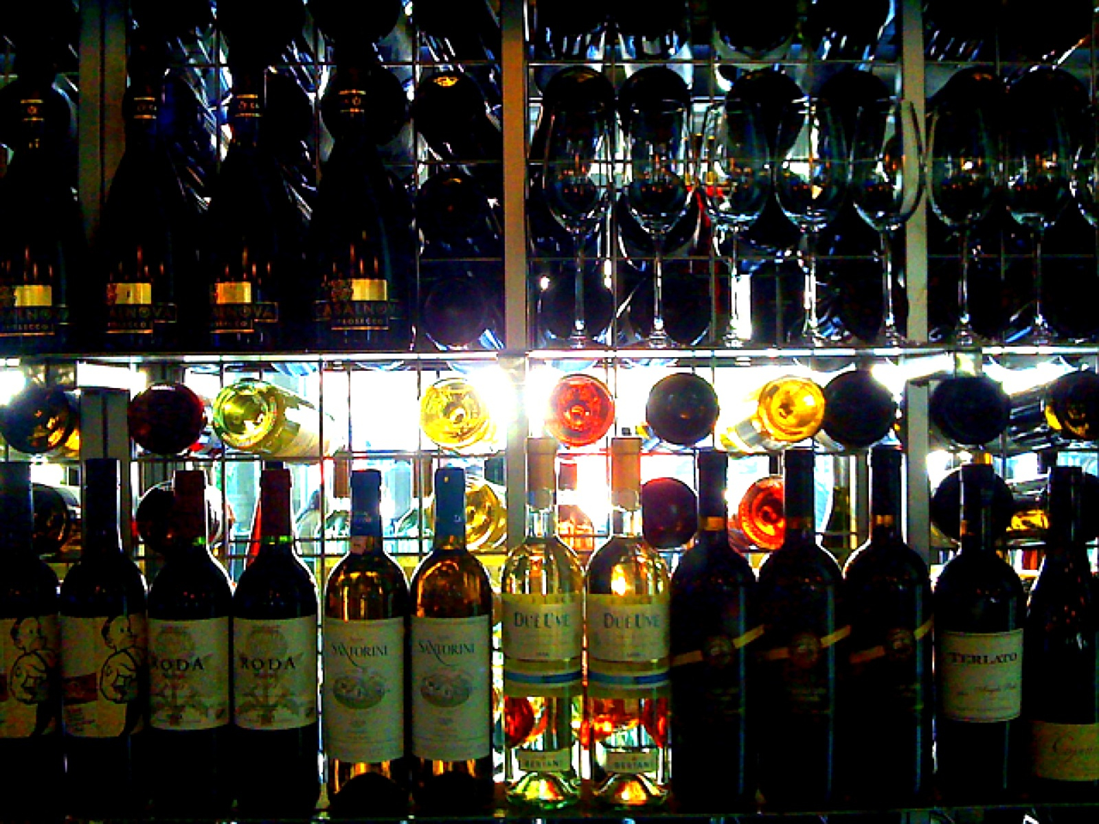 multiple wine bottles with several empty ones behind a fence