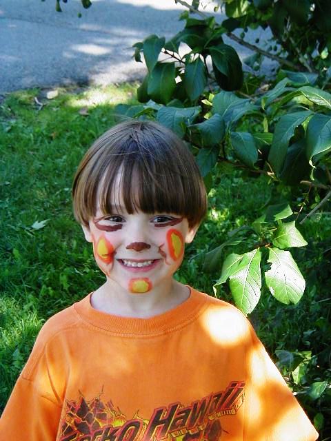 a boy with some orange paint on his face