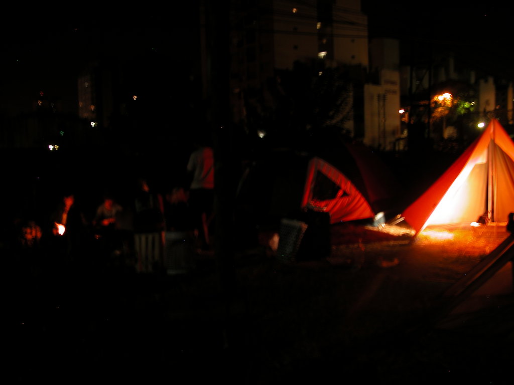 a tent at night with some tents lit up