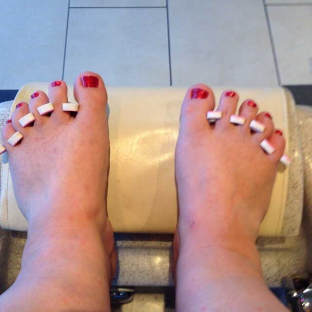the feet of a woman with strips on their nails