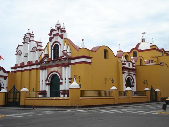 an orange and white church with an open gate