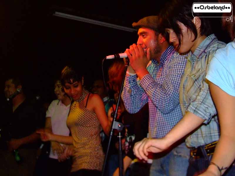 two young adults singing into microphones at concert