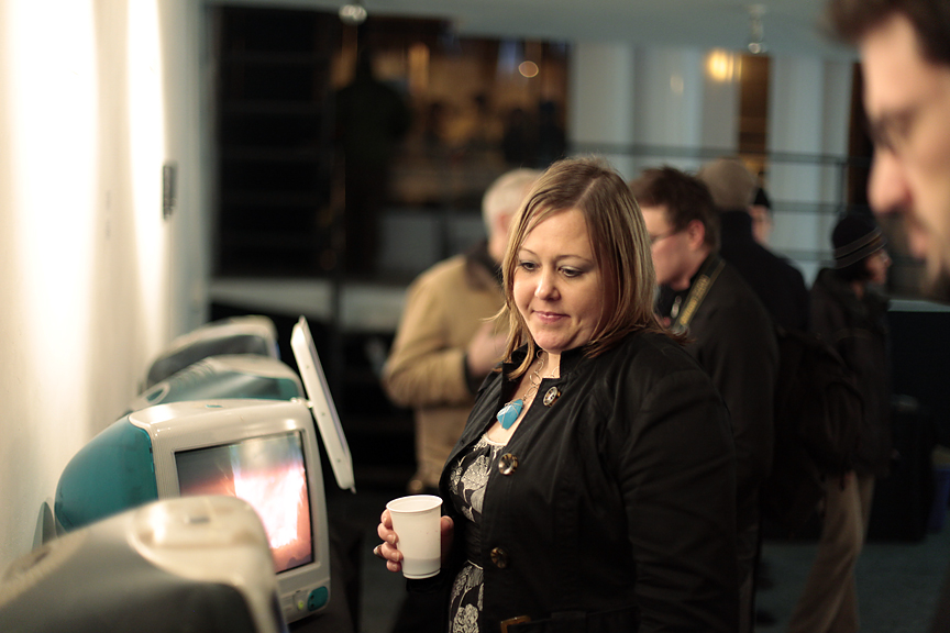 a woman is using a starbucks machine while someone else looks at it