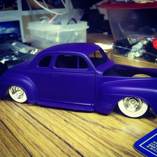 a purple car with chrome wheels sitting on a table