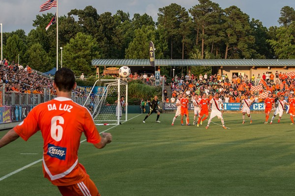 men on opposing teams are playing soccer during a game