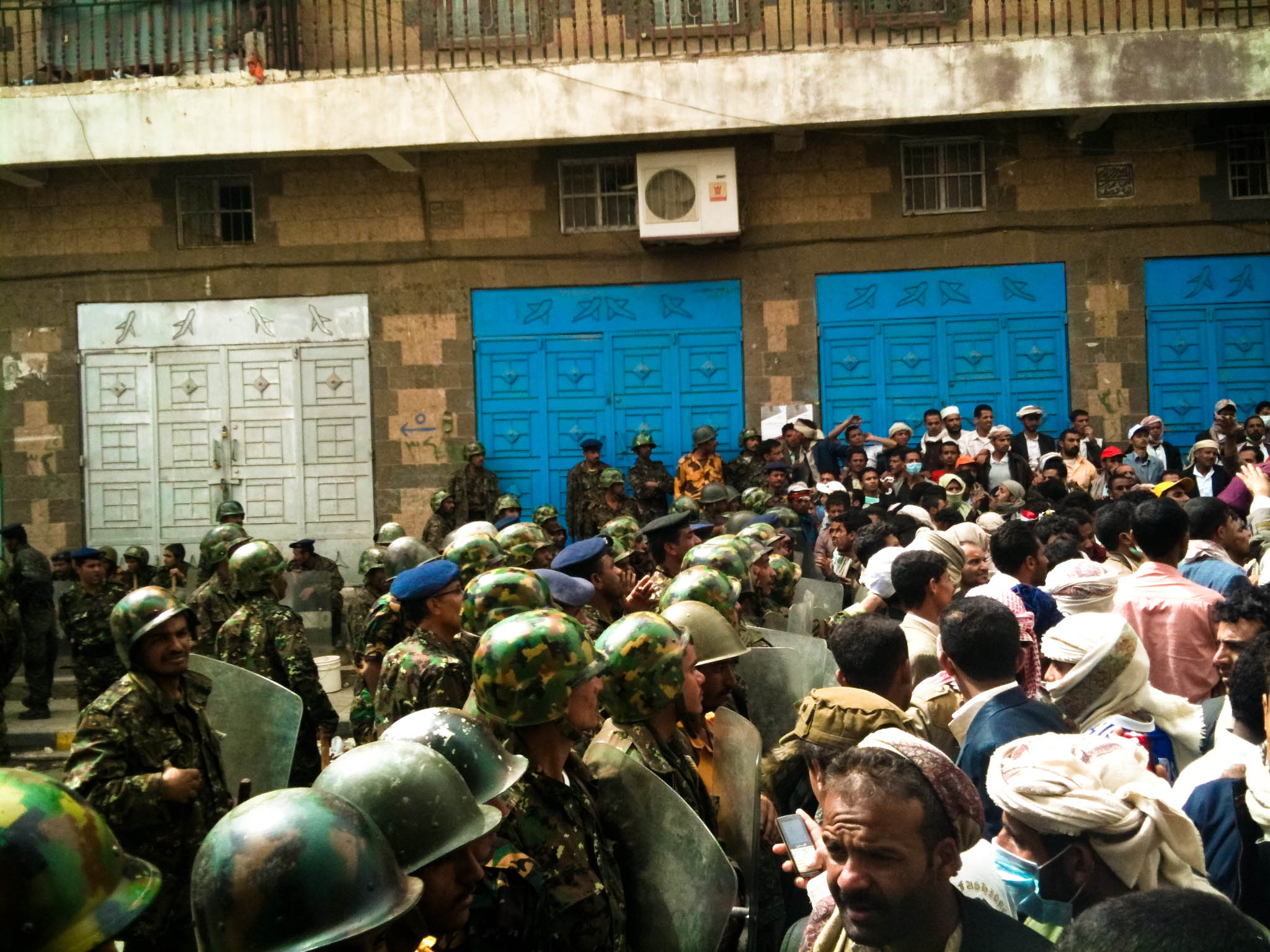 many military men in uniform standing in front of blue doors