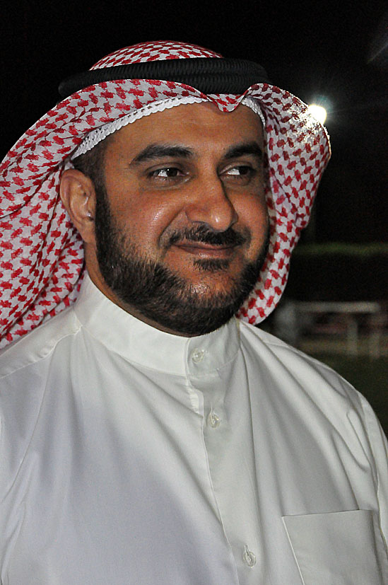 a man wearing a white dress shirt with a red and white checkered head scarf