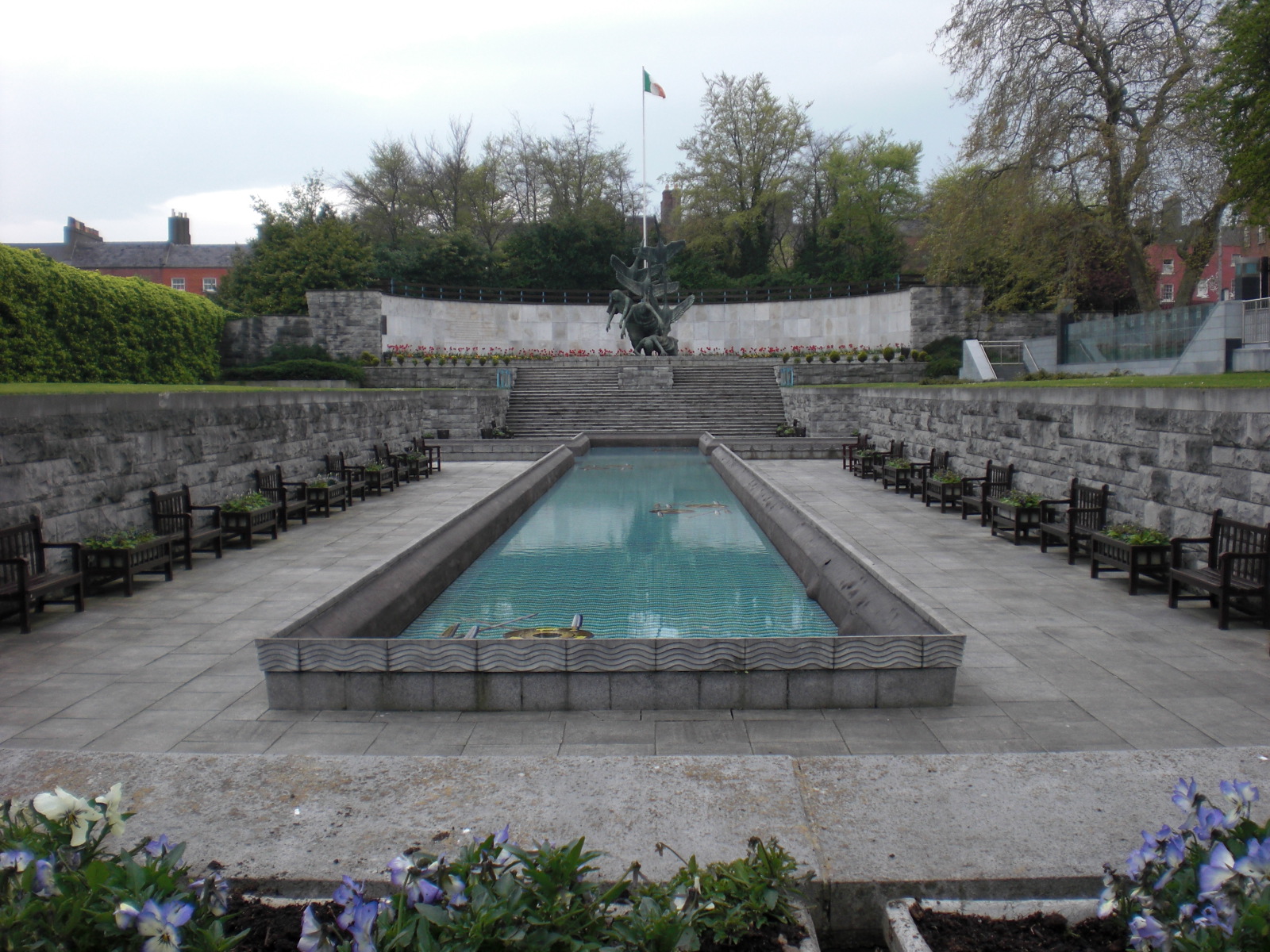 a fountain in the center of a concrete wall