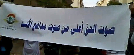 a sign written in a foreign language is held by a man and woman