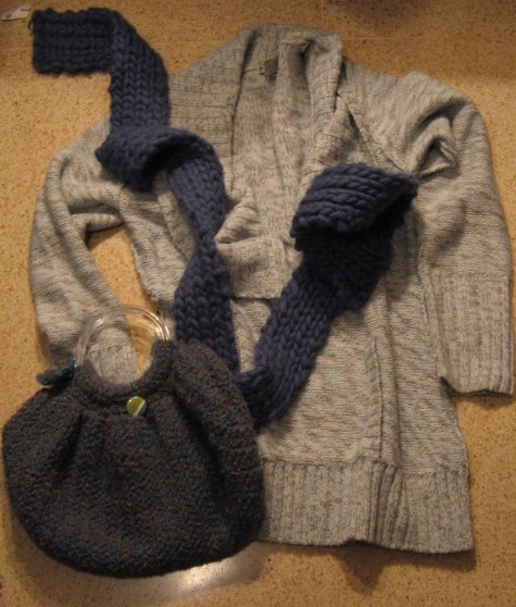 the sweater is gray with blue trim and the scarf is dark grey