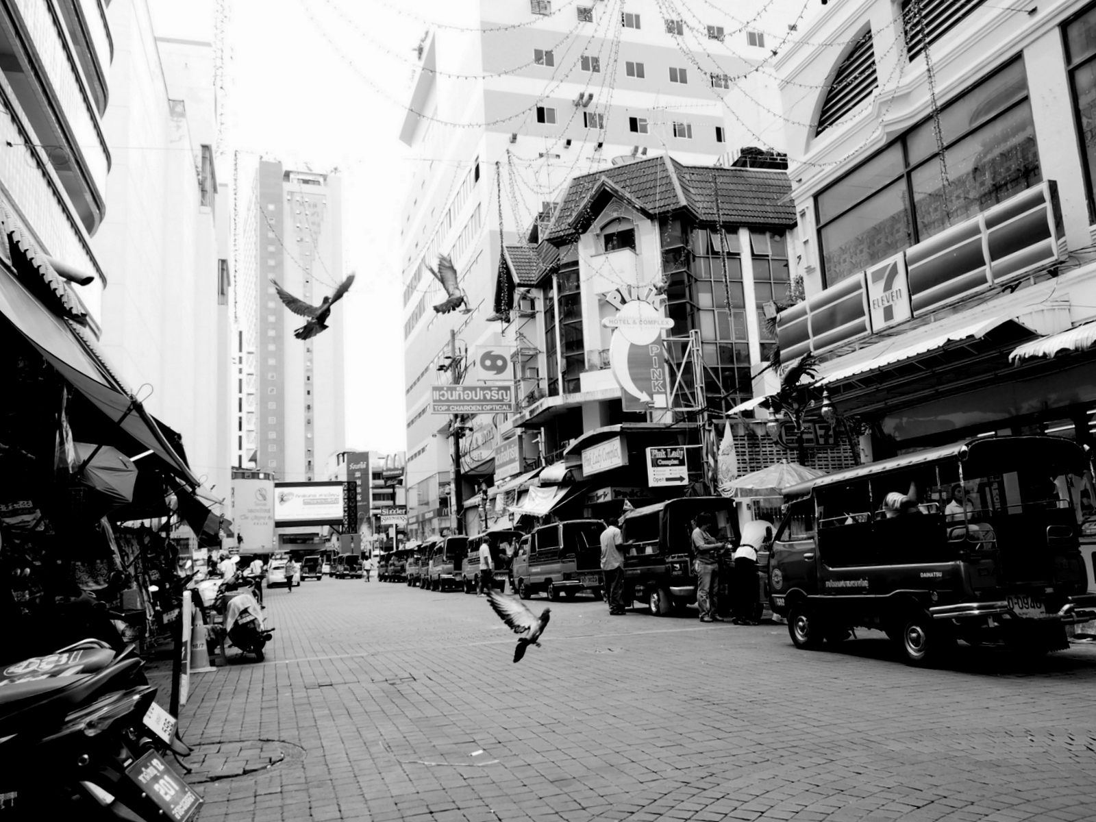 black and white pograph of people walking in a market street