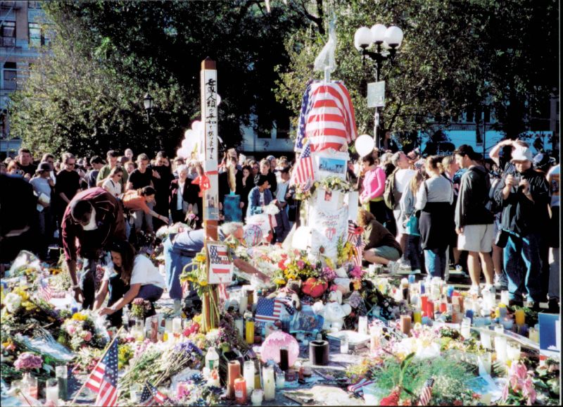 a large group of people surrounding and touching flowers