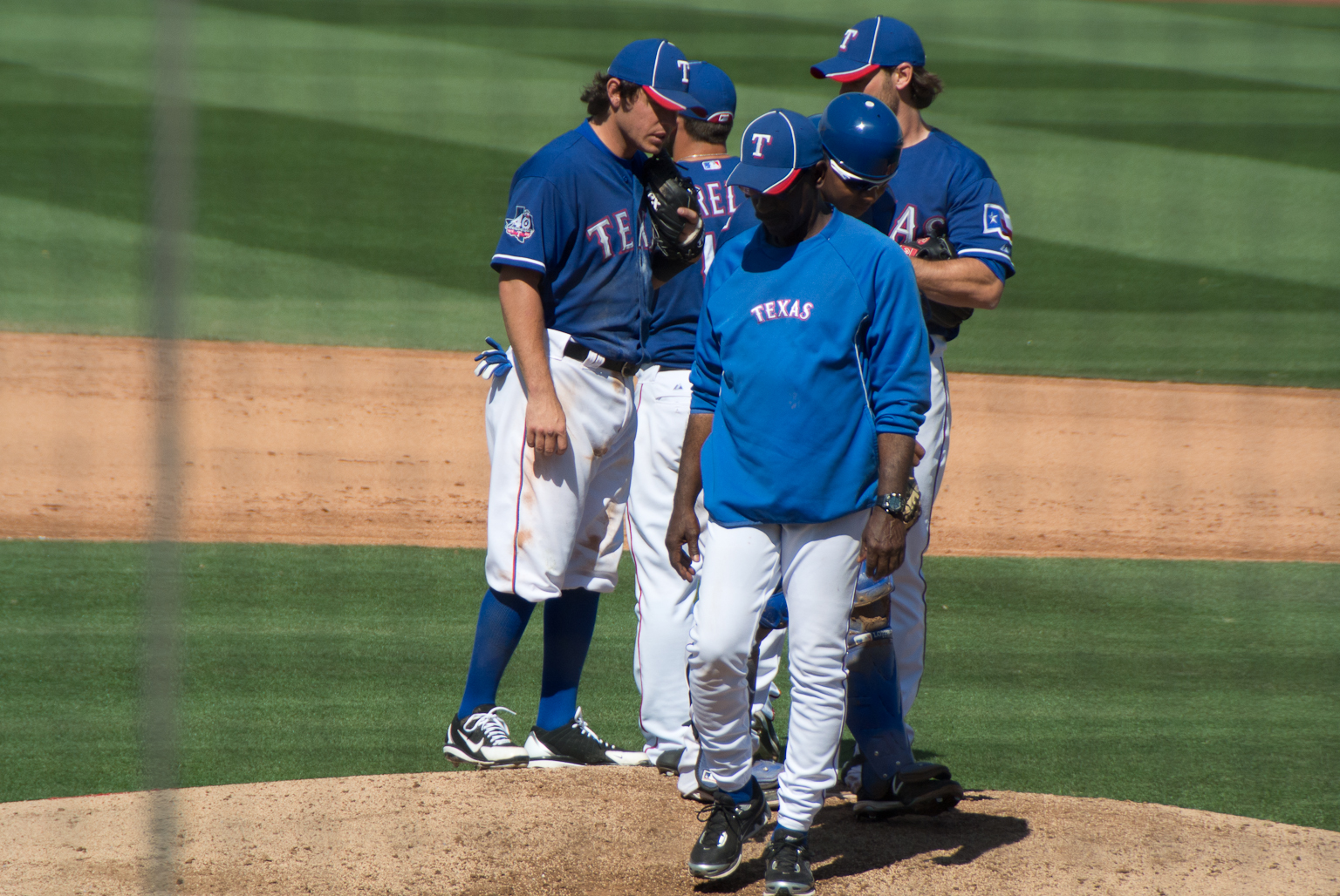 three baseball players standing on the pitchers mound