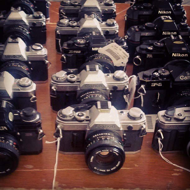an assortment of large, multi - colored cameras displayed for sale