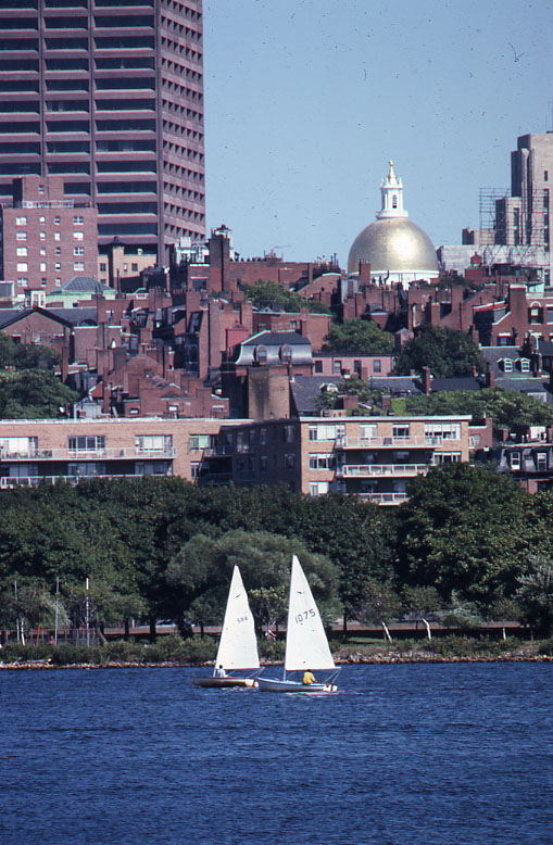 the sailboats are traveling through the water in front of the city