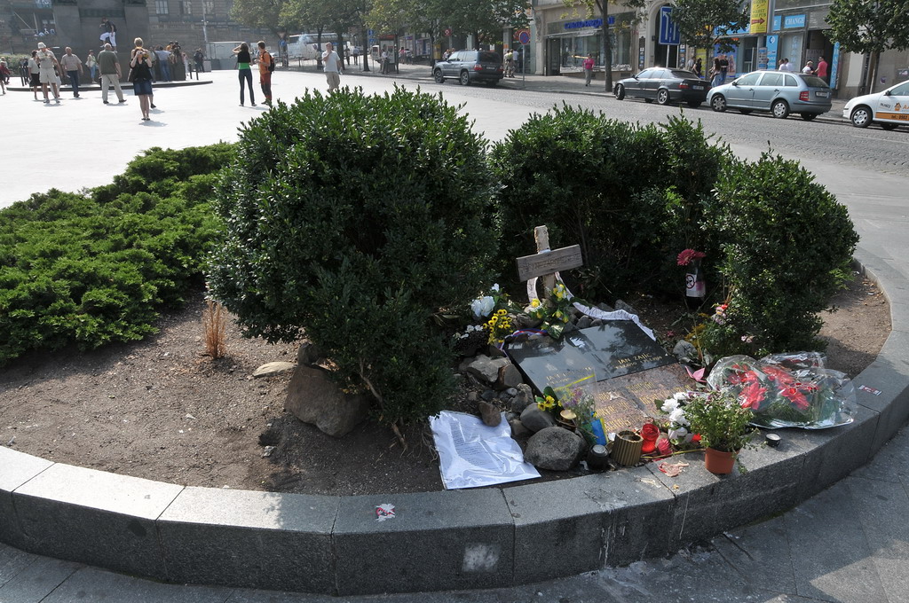 a memorial is placed in the corner with people in the background