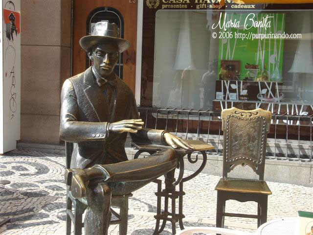 statue depicting a man on the street using a small cart